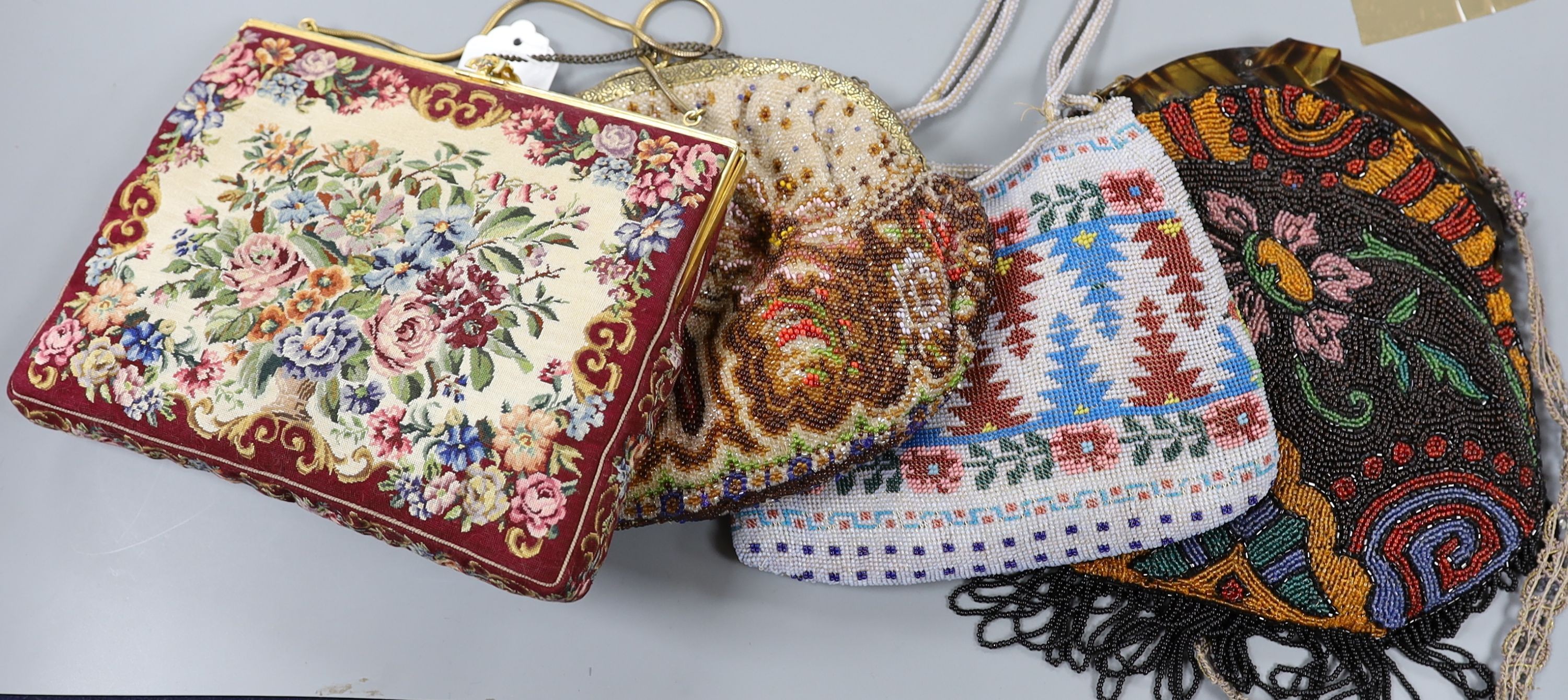 A fine needlework petit point evening bag, a 19th century bible bag, an early 20th century beaded bag and a 1930's beaded bag